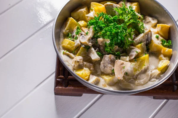 Жареный картофель с курицей, грибным соусом и луком — стоковое фото