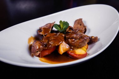 Ördek karaciğer berry sos ve elma ile rosemary ile dekore edilmiştir.