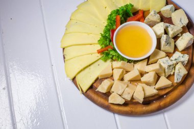 Peynir tabağı farklı peynir, bal ve sebze ile