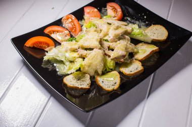 Siyah plaka Sezar salatası jambon ve Bıldırcın yumurta