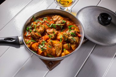 Bir kazan üzerinde domates soslu patates dolması etli