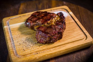 Ahşap tahta çatal ve bıçak otlar baharatlar ve tuz ile sığır eti biftek