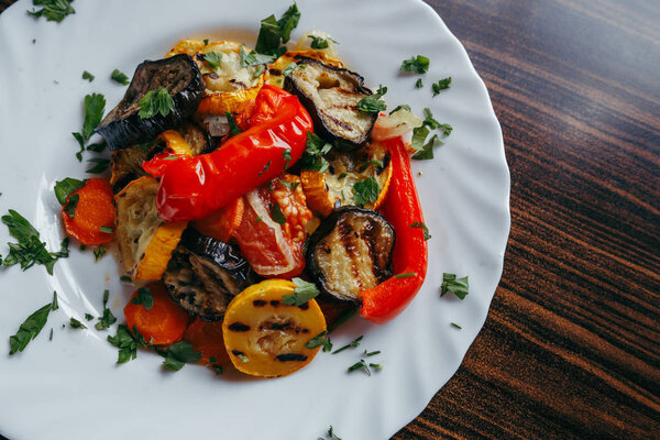 grilled vegetables on a white plate on a wooden table