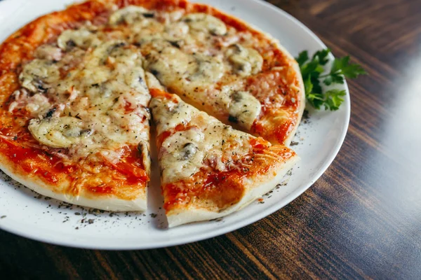 Varm pizza slice med smält ost på ett träbord. — Stockfoto