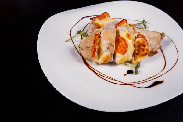 Pittige kipfilet, gebakken met spek, tomaten en cheddarkaas Stockfoto