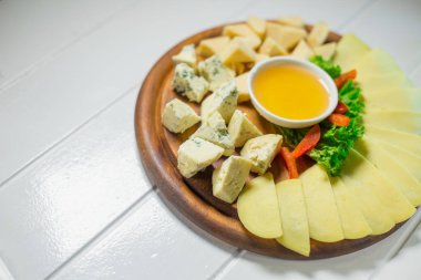 Peynir tabağı farklı peynir, bal ve sebze ile