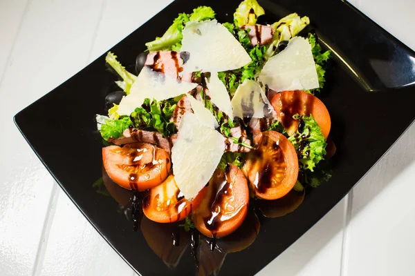 Ensalada de carne de ternera con rúcula, lechuga, tomate, aceitunas y queso parmesano —  Fotos de Stock