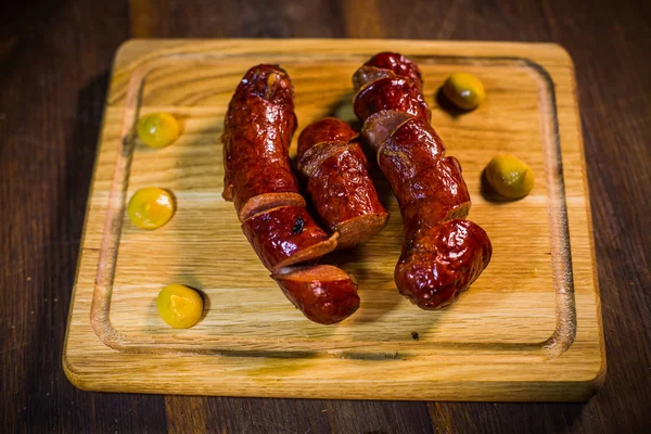 Salchichas fritas en una sartén, con hierbas y especias . — Foto de Stock