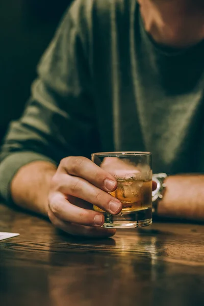guy drinks whiskey with ice at the bar