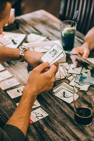 a group of friends plays board games in a cafe and drinks