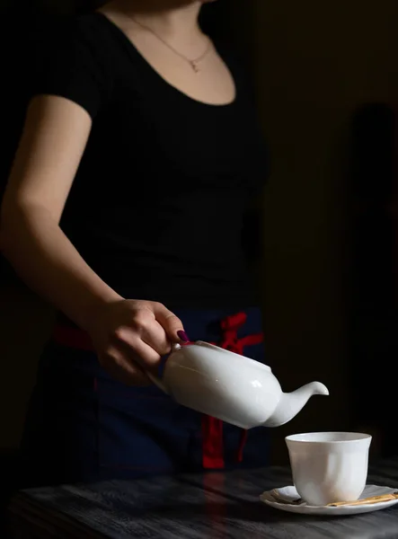 Garson bardağa çay doldurur.