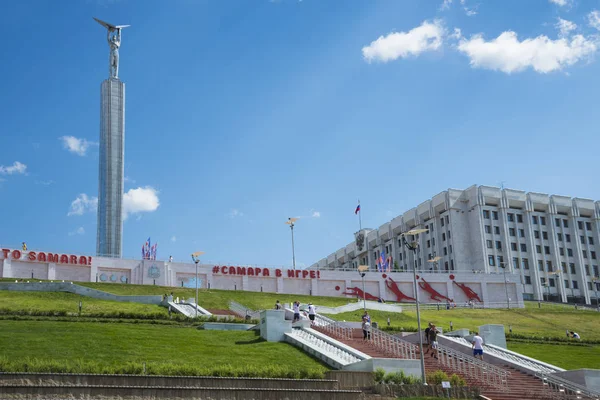 Monumento de gloria en forma de estela con un hombre con alas en sus manos y edificio del gobierno en Samara, Rusia. En un soleado día de verano. 19 junio 2018 —  Fotos de Stock