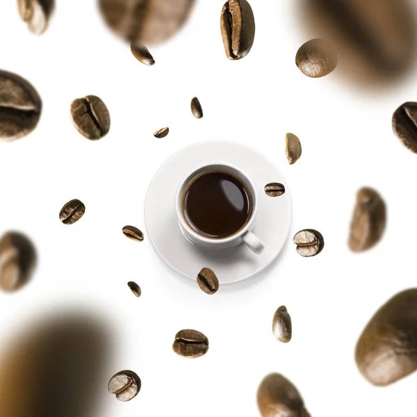 Filiżanka kawy i ziaren kawy w locie na białym tle — Zdjęcie stockowe