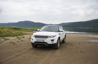 Land Rover Range Rover Samara, Rusya kenti yakınlarında bulutlu bir yaz gününde Volga nehri ve Zhiguli dağlarının arka planda yer almaktadır. 8 Ağustos 2019
