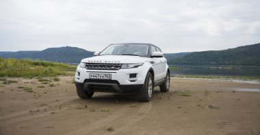Land Rover Range Rover Samara, Rusya kenti yakınlarında bulutlu bir yaz gününde Volga nehri ve Zhiguli dağlarının arka planda yer almaktadır. 8 Ağustos 2019