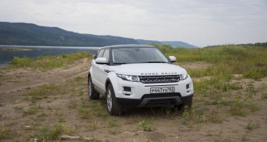 Land Rover Range Rover Samara, Rusya kenti yakınlarında bulutlu bir yaz gününde Volga nehri ve Zhiguli dağlarının arka planda yer almaktadır. 8 Ağustos 2019