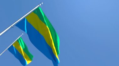 Gabon 'un ulusal bayrağı mavi gökyüzüne karşı rüzgarda dalgalanıyor.