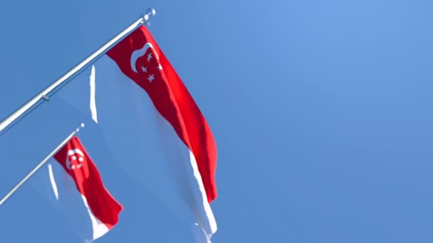 La bandera nacional de Singapur ondea en el viento contra un cielo azul — Vídeos de Stock