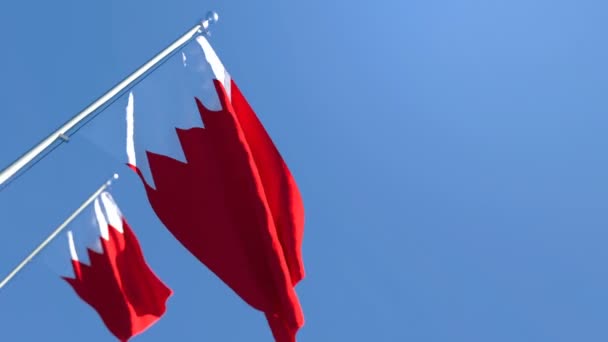 La bandera nacional de Bahréin ondea en el viento contra un cielo azul — Vídeos de Stock