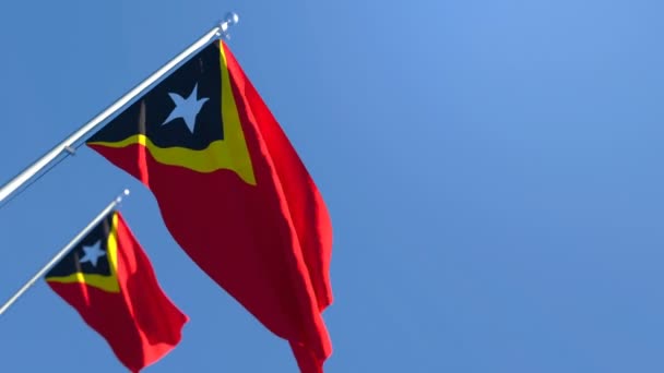 Государственный флаг Восточного Тимора летит на ветру против голубого неба — стоковое видео