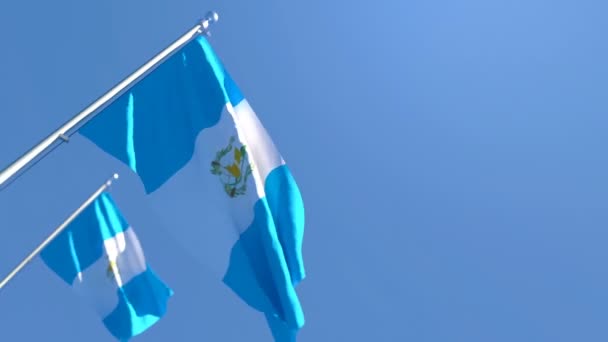 La bandera nacional de Guatemala ondea en el viento contra un cielo azul — Vídeo de stock