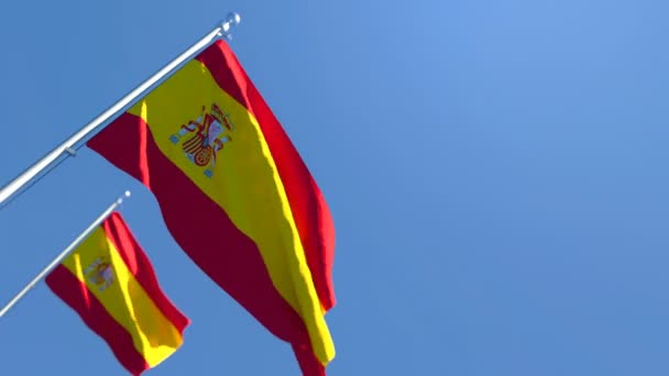 Flaga Hiszpanii wisi na wietrze nad błękitnym niebem. — Wideo stockowe