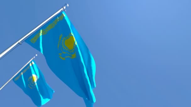 De nationale vlag van Kazachstan vliegt in de wind tegen een blauwe lucht. — Stockvideo