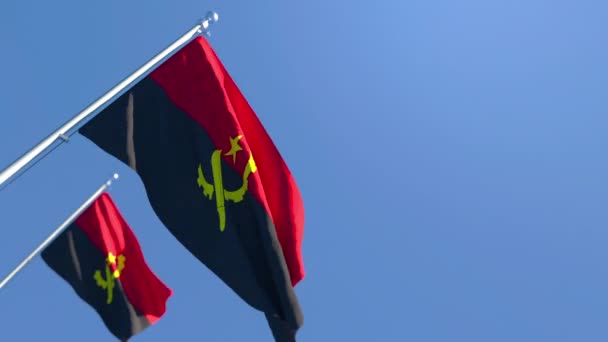 Die angolanische Nationalflagge weht im Wind vor blauem Himmel — Stockvideo