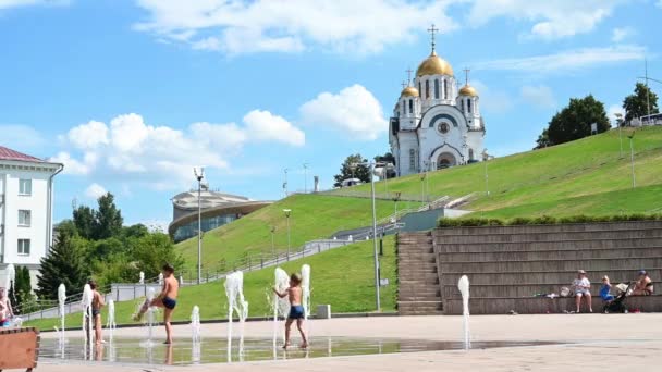 Дети купаются в фонтане на фоне церкви Святого Георгия — стоковое видео