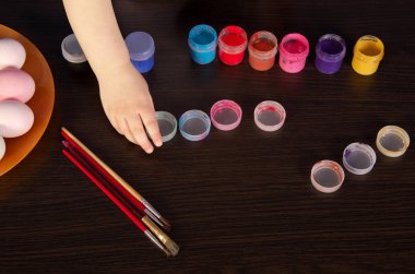 bir çocuk Paskalya yumurtaları boyar. el, fırça ve boya ta