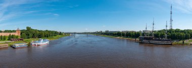 Veliky Novgorod, Rusya - 17 Haziran 2019: Novgorod Kremlin yakınlarındaki panoramik şehir manzarası Alexander Nevsky Köprüsü ve Volkhov nehri üzerindeki su araçları.