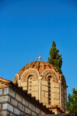 Yunan Ortodoks Kilisesi çatı bir güvercin ile mavi gök yeşil ağaçlar ile çapraz üzerinde kubbeli