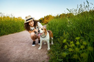 Otların arasındaki orman yolunda köpeği olan bir kız..