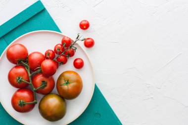Beyaz tabak, turkuaz tepsi ve beyaz arka plan üzerinde metin mesajı için alan ile domates farklı türleri