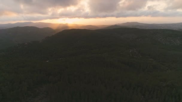 暗い山の森の上をゆっくりと飛び上がる 雲の美しい景色と太陽の光のビームと素晴らしいゴールデンアワーの夕日 空中映画4Kドローン映像 — ストック動画