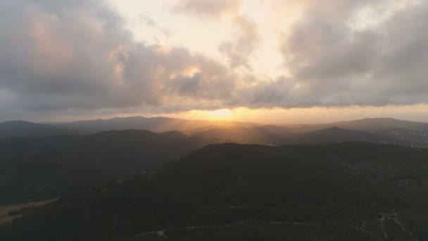 山の上をゆっくりと戻る雲の美しい景色と太陽の光のビームと素晴らしいゴールデンアワーの夕日 空中映画4Kドローン映像 — ストック動画