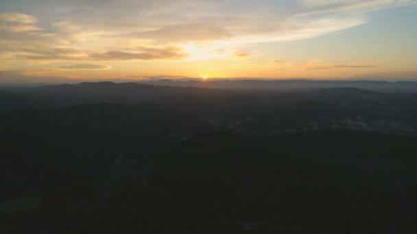 山の上をゆっくりと戻る雲と素晴らしいゴールデンアワーの夕日の美しい景色 空中映画4Kドローン映像 — ストック動画