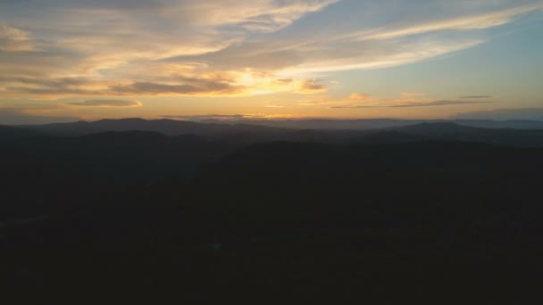 暗い山の森の上をゆっくりと飛び上がる 雲と素晴らしいゴールデンアワーの夕日の美しい景色 空中映画4Kドローン映像 — ストック動画