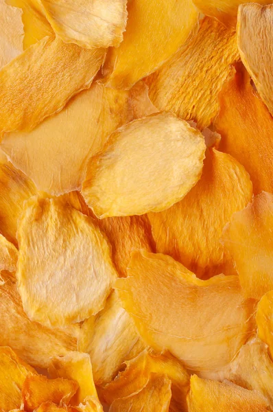 Kurutulmuş mango dilimleri (cips) arka plan. Gevrek meyve dilimleri, adet susuz. Kurutulmuş mango meyve yığını. Sağlıklı yemek. Yakın çekim. Üstten görünüm, görünüm yukarıdan, yat. İzole. Kimse.