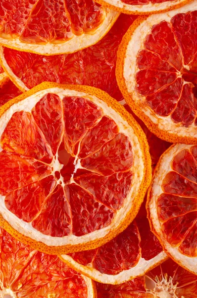 Greyfurt dilim cips arka plan kurumuş. Gevrek meyve dilimleri susuz. Yığın, yığın güneş gevrek greyfurt kurumuş. Sağlıklı yemek yemek. En iyi görünümü kapatın yukarıdan görüş, düz göl kenarında yatıyordu. Doku