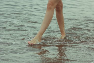 Kadın çıplak ayak yaz sahilde yürüyüş. Deniz suyu ve kum dalga sahilde seyahat kavram yürümeye.
