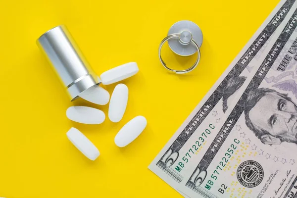 Metal container for pills and money on a yellow background, concept of expensive drugs, close-up