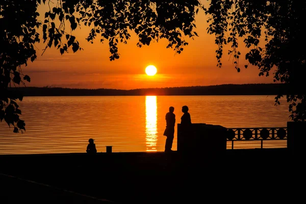 Silhouette of a couple in love and child at sunset or sunrise