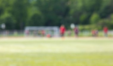 Bokeh arka plan yeşil çim alan futbolcular ile bulanık.