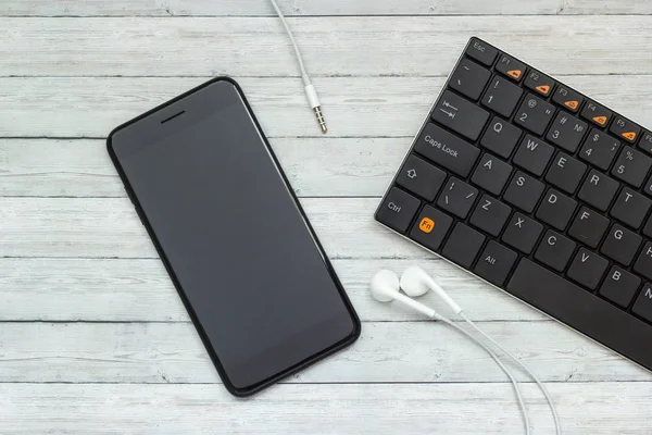Smartphone Headphones Keyboard Wooden Background Concept Modern Technology — Stock Photo, Image