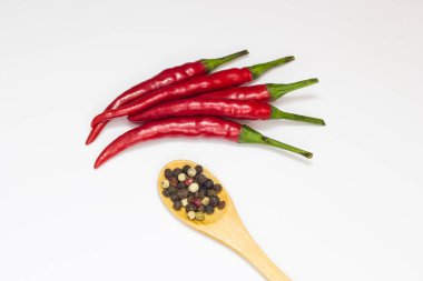 Yakın çekim üstten görünüm kırmızı biber biber beyaz zemin üzerine tahta kaşık ile
