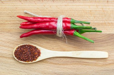 Kırmızı biber biber, yakın çekim üstten görünüm bağlı örgü ve ahşap zemin üzerine kaşık ile