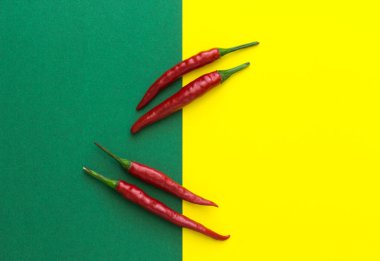 üstten görünüm, sarı-yeşil arka plan üzerinde dört kırmızı biber