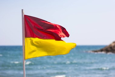 Deniz kenarı kırmızı sarı bayrak. Hayat Emanet kavramı.