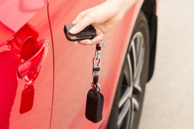 Female hand opens the door of a red car clipart
